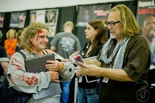 Patricia Silverberg (left) gets an autograph from Greg Nicotero as they walk around during Walker Stalker Con at the Atlanta Convention Center at AmericasMart on Saturday, November 2, 2013. 