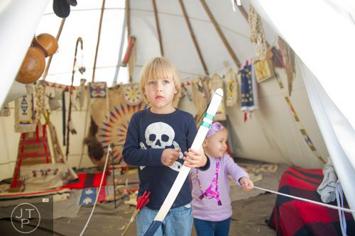 Walker Madsen (left) and his sister Greer exit a teepee during the Indian Festival & Pow-Wow at Stone Mountain Park on Sunday, November 3, 2013. 