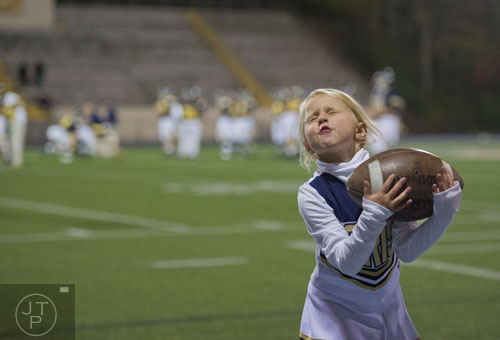 Marist fan Evie Shropshire catches a football as the team warms up on the field before their game against Carver-Atlanta on Friday, November 8, 2013. 