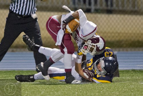 Carver-Atlanta's Charlie Daniel Warren (left) is pulled to the ground by Marist's Fletcher Malloy on Friday, November 8, 2013. 