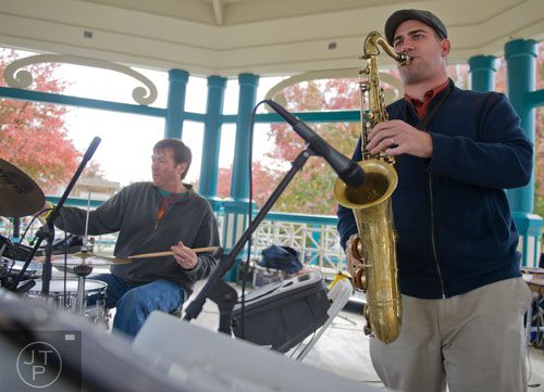 Mace Hibbard plays a solo on his saxophone while Mike Hinton plays the drums during the Decatur Wine Festival on Saturday, November 9, 2013. 