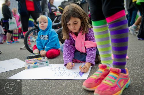 Sydney Riepe (center) and her brother Mason make signs before the start of the 2013 Girls on the Run 5k at Atlantic Station in Atlanta on Sunday, November 10, 2013. 
