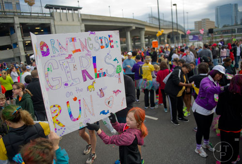 Emerson Brasfield (center) holds up a sign for the Morningside team before the start of the 2013 Girls on the Run 5k at Atlantic Station in Atlanta on Sunday, November 10, 2013. 
