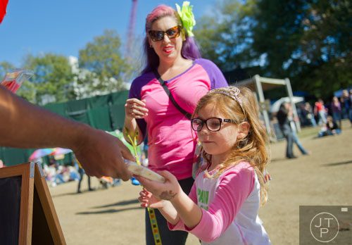 Stella Bridges (right) and her mother Kamilla are handed popsicles during the 3rd Annual King of Pops Field Day at Masquerade Music Park in Atlanta on Sunday, November 10, 2013. 