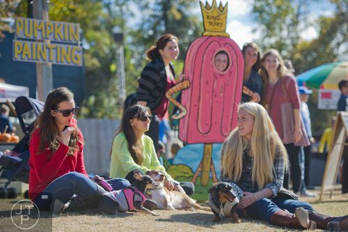 Mattie Wolf (left) eats a popsicle as she sits with Ana Monteiro and Remy Van Sanford during the 3rd Annual King of Pops Field Day at Masquerade Music Park in Atlanta on Sunday, November 10, 2013. 