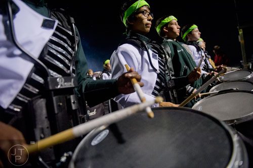 Collins Hill's Angel Rodriguez (center) plays his snare drum with the rest of the drumline before the start of their game against Walton on Friday, November 15, 2013.