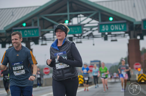 Leah Abbott (center) and Matt Gillentine run down 400 after making it through the toll booth during the GA 400 Pay the Last Toll Race in Atlanta on Sunday, November 17, 2013. 