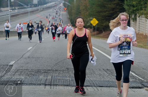 Ashley Etheridge (right) and Choua Thao run up the on ramp at Lenox Rd. as they near the finish line for the GA 400 Pay the Last Toll Race in Atlanta on Sunday, November 17, 2013. 