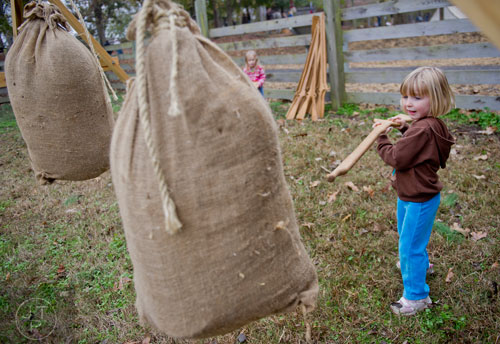 Nora Badinger pokes a bag of dirt with a replica of a musket during A Civil War Christmas at McDaniel Farm Park in Duluth on Saturday, November 16, 2013.