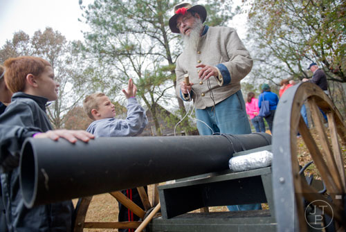 Frank Russell (right) explains how a cannon works to Luke Metz and his brother London during A Civil War Christmas at McDaniel Farm Park in Duluth on Saturday, November 16, 2013.