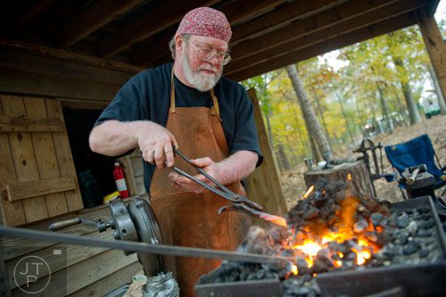 Doc Watson pulls a piece of metal out of the fire as he gives a blacksmithing demonstration during A Civil War Christmas at McDaniel Farm Park in Duluth on Saturday, November 16, 2013. 