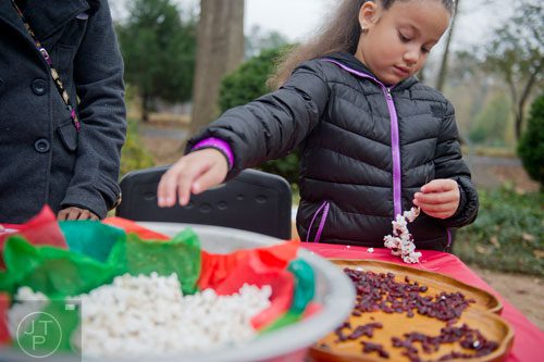 Dilenney Guzman reaches for a handful of popcorn as she makes a popcorn and cranberry necklace during A Civil War Christmas at McDaniel Farm Park in Duluth on Saturday, November 16, 2013. 