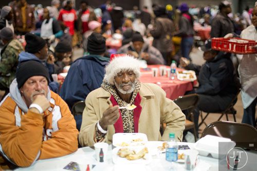 Clarence Miller (center) sits next to Gary Sanders as they eat a five course Thanksgiving meal during the Hosea Feed the Hungry and Homeless annual Thanksgiving meal at the Georgia World Congress Center in Atlanta on Thursday, November 28, 2013. 