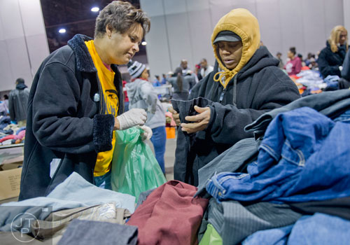 Monique Valrie-White (right) picks out some new clothes with the help of Kathryn Whitbourne during the Hosea Feed the Hungry and Homeless annual Thanksgiving meal at the Georgia World Congress Center in Atlanta on Thursday, November 28, 2013.