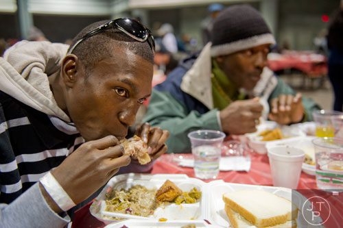 Charles Agim (left) and Stanley Brown eat a five course Thanksgiving meal during the Hosea Feed the Hungry and Homeless annual Thanksgiving meal at the Georgia World Congress Center in Atlanta on Thursday, November 28, 2013. 
