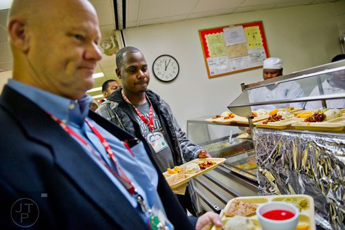 Cleo Anderson (center) moves through the cafeteria line picking up his tray of food for lunch as George Nicholas (left) exits the line at the Salvation Army's Red Shield facility in Atlanta on Tuesday, November 12, 2013.