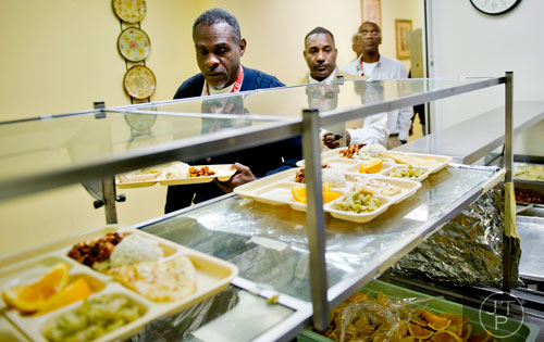 Robert Conley Jr. (left), Alfred Higdon and John Dacus move through the cafeteria line picks for lunch at the Salvation Army's Red Shield facility in Atlanta on Tuesday, November 12, 2013. 