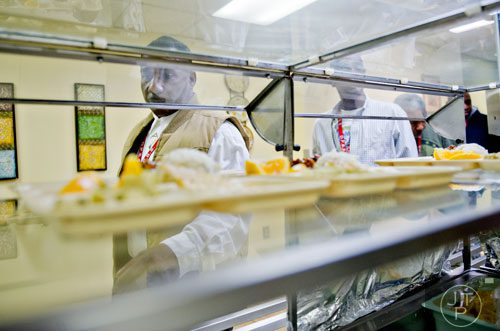 Alfred Higdon (left) picks up a tray of food for lunch at the Salvation Army's Red Shield facility in Atlanta on Tuesday, November 12, 2013.