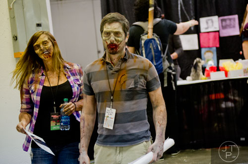Dressed as zombies, Natalie Wilkerson (left) and Mike Dupree hold their signed autographs from Norman Reedus during Walker Stalker Con at the Atlanta Convention Center at AmericasMart on Saturday, November 2, 2013.