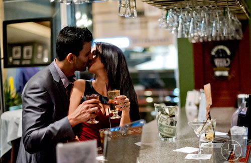 Sahil Musani kisses his wife Kristle as they stand at the bar during a break in the performance of "Somewhere Over the Rainbow Someone Dies" at Agatha's A Taste of Mystery in downtown Atlanta on Saturday, November 2, 2013. 