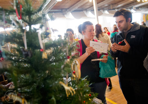 Jessica Davis (left) shows an item to her husband Jared as they shop during the Indie Craft Experience at Ambient Plus Studio in Atlanta on Saturday, November 23, 2013. 