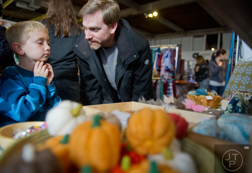Carter Wilson (left) and his father Todd look at the items for sale at the Felt Jar booth during the Indie Craft Experience at Ambient Plus Studio in Atlanta on Saturday, November 23, 2013. 