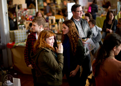 Hilary Staff (center) walks the aisles of vendors during the Indie Craft Experience at Ambient Plus Studio in Atlanta on Saturday, November 23, 2013. 