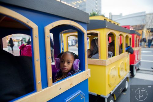 Eva Jimerson (left) looks out of the window of the train as she rides down the street at Atlantic Station in Atlanta during the annual Christmas tree lighting on Saturday, November 23, 2013. 