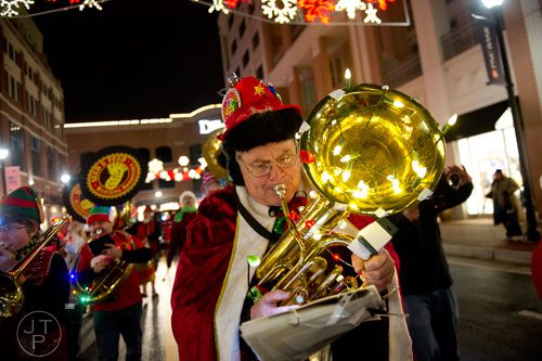 Bob Dorff plays his instrument as he marches down the street at Atlantic Station in Atlanta during the annual Christmas tree lighting on Saturday, November 23, 2013. 