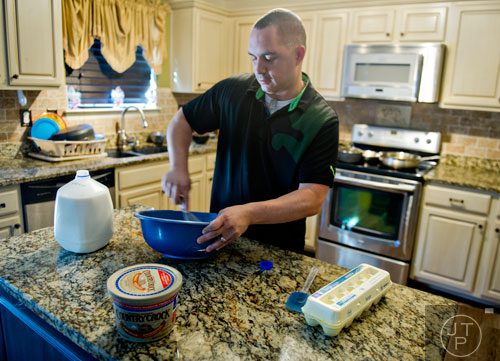 Pablo Borrero cooks breakfast for his wife and five children at their home in Dacula on Sunday, November 24, 2013.