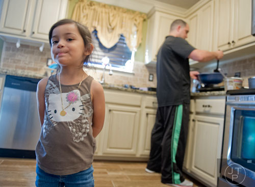 Autumn Borrero (left) stands in his kitchen as her father Pablo cooks breakfast at their home in Dacula on Sunday, November 24, 2013.