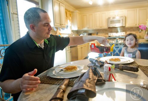 Pablo Borrero (left) pours syrup on his daughter Autumn's pancake at their home in Dacula on Sunday, November 24, 2013. 