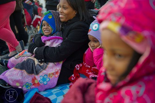 Quentin Hathorn (left) sits in his mother Sharon's lap as they, his sister Desirae and cousin Mya Moore wait for the start of the 66th annual Macy's Great Tree Lighting at Lenox Square Mall in Atlanta on Thursday, November 28, 2013. 