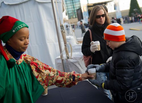Jacob Lassiter (right) and his mother Rebecca are handed cups of hot chocolate by Torie Whitley during the 66th annual Macy's Great Tree Lighting at Lenox Square Mall in Atlanta on Thursday, November 28, 2013. 