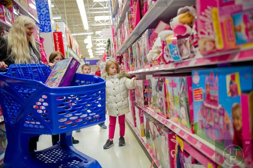 Lily Anderson (right) looks at the many dolls on display as she shops with her grandmother Rita Spencer at the Toys R Us off of Cobb Parkway in Atlanta on Friday, November 29, 2013. 