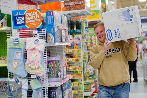 Brent Estes carries a crazy coupe on his shoulder as he shops at the Toys R Us off of Cobb Parkway in Atlanta on Friday, November 29, 2013. 