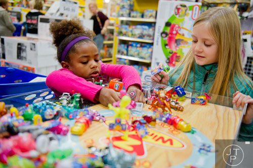 Macy East (left) and her sister Eva play with wind up toys on display at the Toys R Us off of Cobb Parkway in Atlanta on Friday, November 29, 2013. 