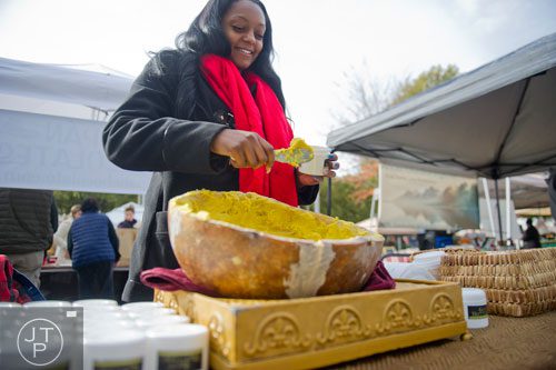 Alexis Seldon fills a container with fresh shea butter at the farmers market in Marietta Square on Saturday, November 9, 2013. 