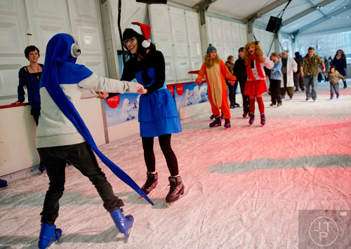 Eli Wall (left) skates backwards while helping Rachel Moore learn how to ice skate at Centennial Olympic Park on Sunday, December 8, 2013. 