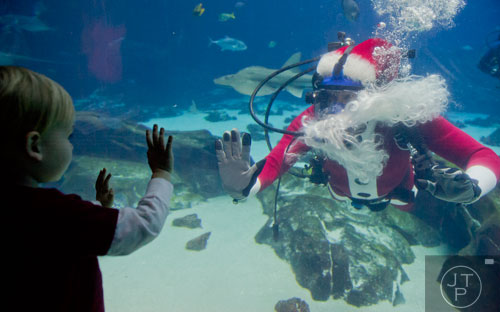 Scuba Claus (right) visits with Ethan Schuman at the Georgia Aquarium during an appearance on Friday, December 13, 2013.