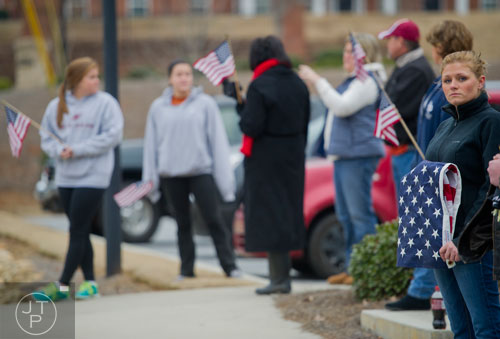 Tabatha King (right) holds an American flag as she and others wait to pay tribute to United States Army Sergeant First Class Omar Forde at NorthStar Church in Kennesaw on Saturday, December 28, 2013. 