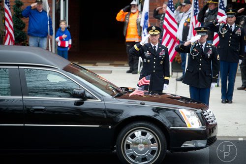 Members of the honor guard for United States Army Sergeant First Class Omar Forde salute as the hearse arrives at NorthStar Church in Kennesaw on Saturday, December 28, 2013.