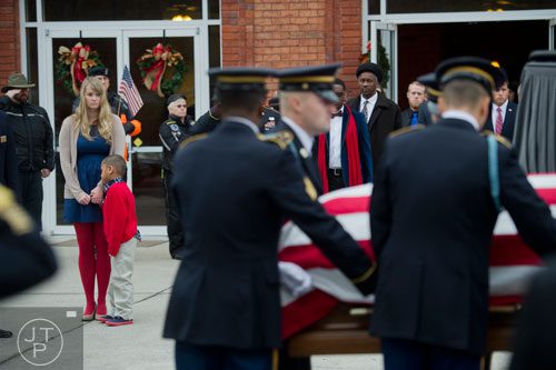 Megan Forde (left) and her son Ayden watch as United States Army SFC Omar Forde's casket is loaded into a hearse after his funeral service at NorthStar Church in Kennesaw on Saturday, December 28, 2013. 
