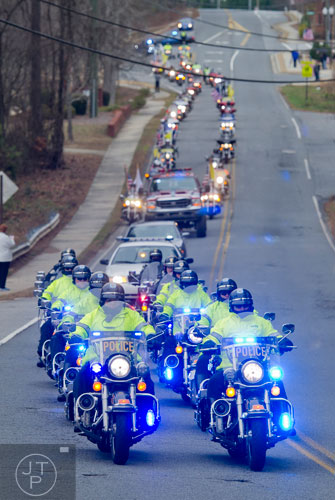 Police officers lead the procession for United States Army SFC Omar Forde down Blue Springs Rd. in Kennesaw as they make their way to the Georgia National Cemetery in Canton on Saturday, December 28, 2013. 