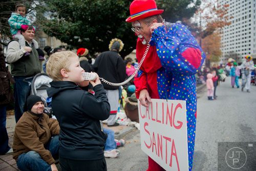 Brodie Harr (left) talks to Santa on Mike Maguigan's phone during the 33rd annual Children's Christmas Parade in Atlanta on Saturday, December 7, 2013. 