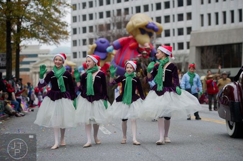 The Atlanta Ballet's Hanna Willis (left), Liane Bouchillon, Abby Boivin and Sydne Twardos wave to the crowd during the 33rd annual Children's Christmas Parade in Atlanta on Saturday, December 7, 2013. 