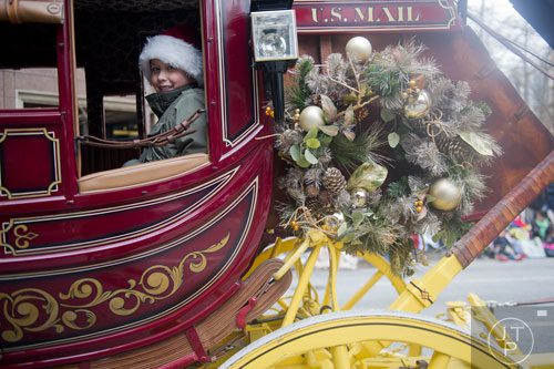 Blake Petty rides in a stage coach down Peachtree Street during the 33rd annual Children's Christmas Parade in Atlanta on Saturday, December 7, 2013. 
