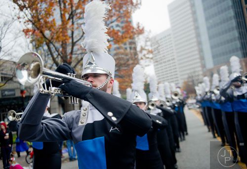 The Spirit of Atlanta's Ian Roberson (left) plays his trumpet as he marches down Peachtree Street during the 33rd annual Children's Christmas Parade in Atlanta on Saturday, December 7, 2013. 