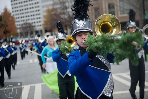North Paulding High School's Tyler Cole (center) plays his trombone as he marches down Peachtree Street during the 33rd annual Children's Christmas Parade in Atlanta on Saturday, December 7, 2013. 