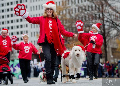 Grace Kelly (center) and her owner Cheri Gatland-Lightner march down Peachtree Street during the 33rd annual Children's Christmas Parade in Atlanta on Saturday, December 7, 2013. 